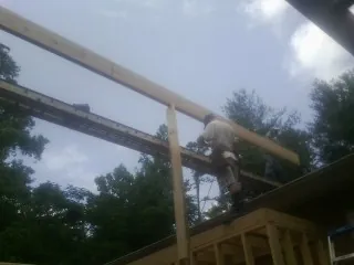 Carpenter setting a ridge beam over a new addition frame — Ice Dam Removal by Roofing Brothers in Heath