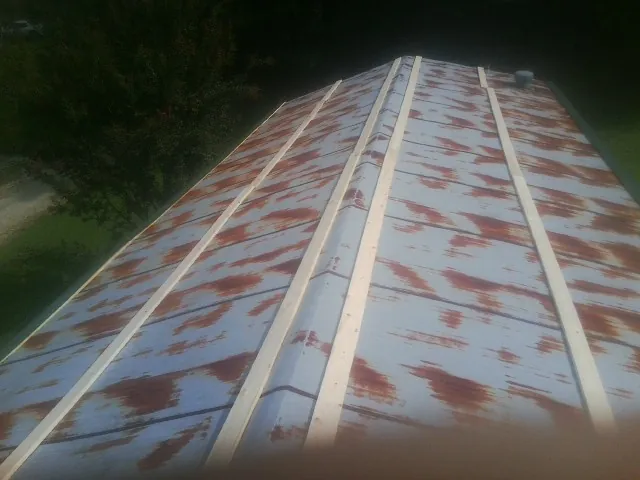 Rusted metal roof panels with new wood purlins before replacement — Storm Damage Roof Repair in Heath by Roofing Brothers