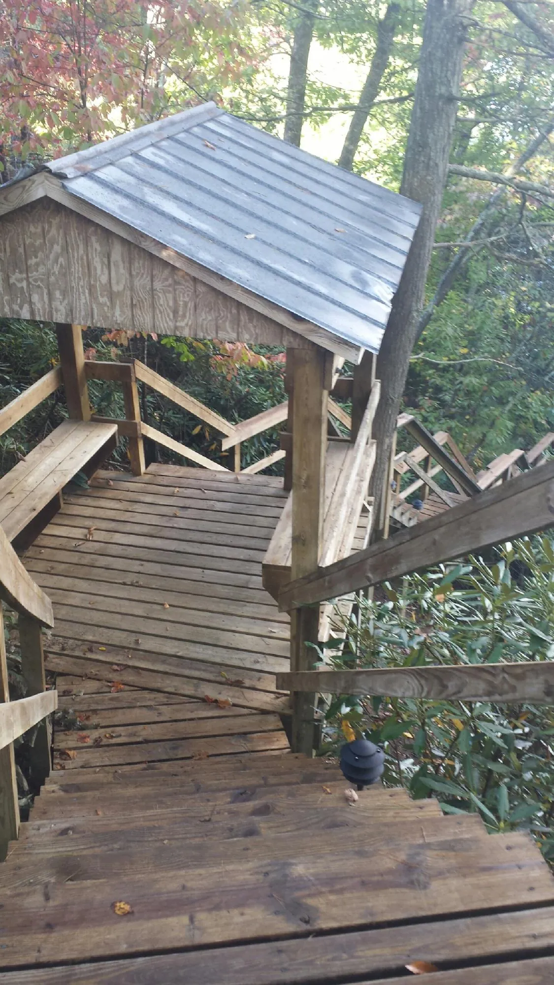 Metal roofed shelter over wooden steps on a wooded walkway — Skylight Repair & Installation work by our crew in Heath